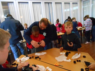 Members of the Voortrekker Club assisting children with their binoculars 