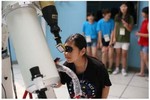 Children look through telescopes